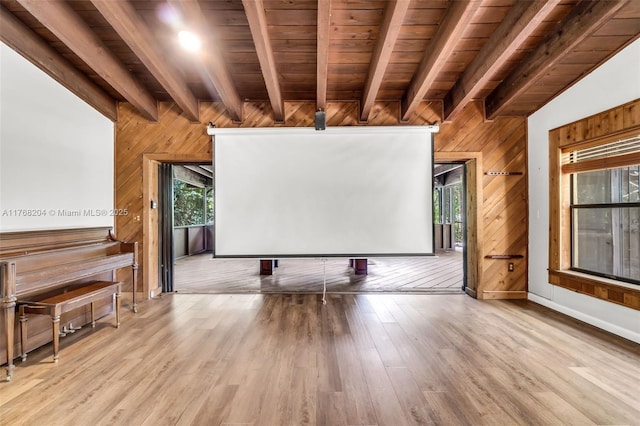 living area featuring baseboards, wooden ceiling, wooden walls, beamed ceiling, and wood finished floors