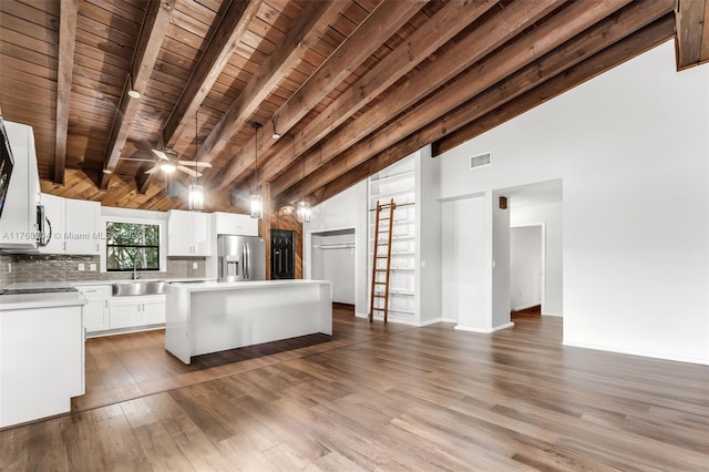 unfurnished living room featuring wooden ceiling, a sink, visible vents, vaulted ceiling with beams, and wood finished floors