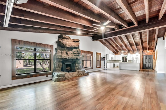 unfurnished living room featuring a fireplace, a ceiling fan, light wood-style floors, and wood ceiling