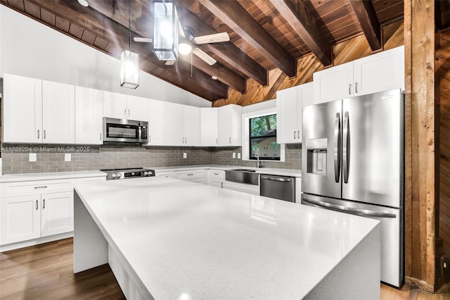 kitchen featuring wooden ceiling, lofted ceiling with beams, light countertops, stainless steel appliances, and a sink