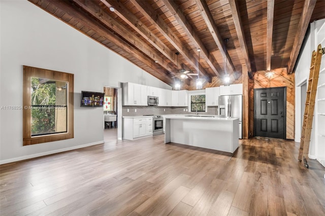 kitchen featuring wooden ceiling, light countertops, appliances with stainless steel finishes, white cabinetry, and wood finished floors