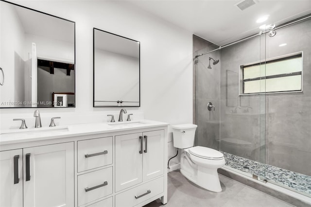 bathroom featuring toilet, a stall shower, a sink, and visible vents
