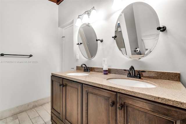 full bath featuring a sink, toilet, and double vanity