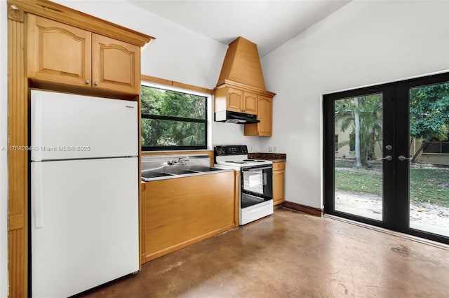 kitchen featuring white appliances, concrete flooring, under cabinet range hood, a healthy amount of sunlight, and a sink