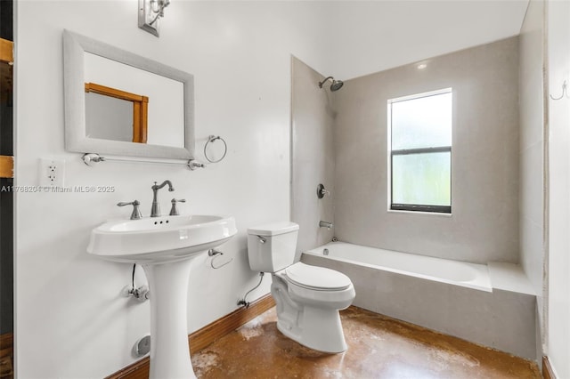 bathroom featuring toilet, concrete flooring, baseboards, and washtub / shower combination