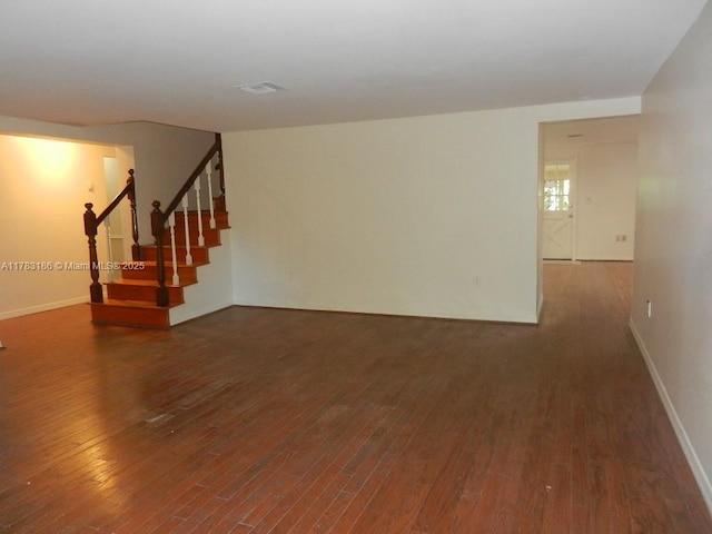 unfurnished living room with stairs, baseboards, and dark wood-style floors