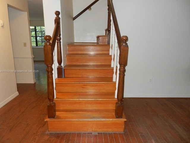 staircase with baseboards and wood finished floors