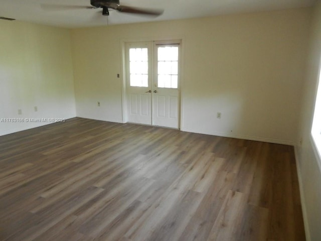 empty room featuring a ceiling fan, baseboards, and wood finished floors