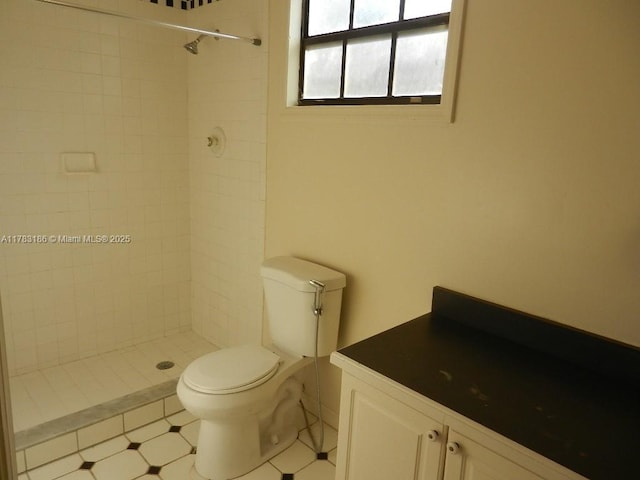 bathroom featuring vanity, toilet, and tiled shower