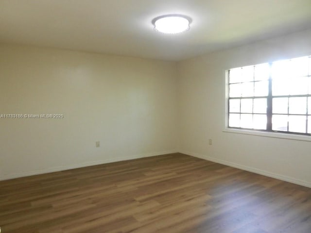 unfurnished room featuring baseboards and wood finished floors