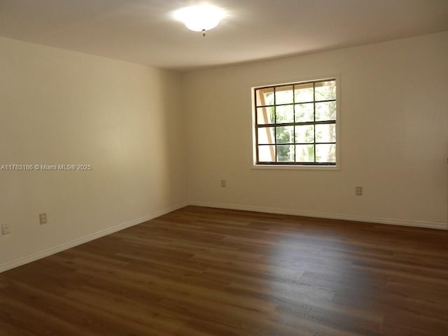unfurnished room featuring baseboards and wood finished floors