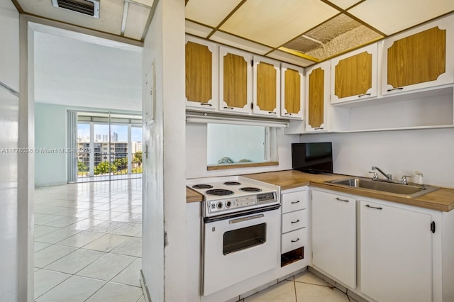 2851 Leonard Dr Unit J610, Aventura, FL 33160 - kitchen with white electric stove, light tile patterned floors, a sink, open shelves, and white cabinets