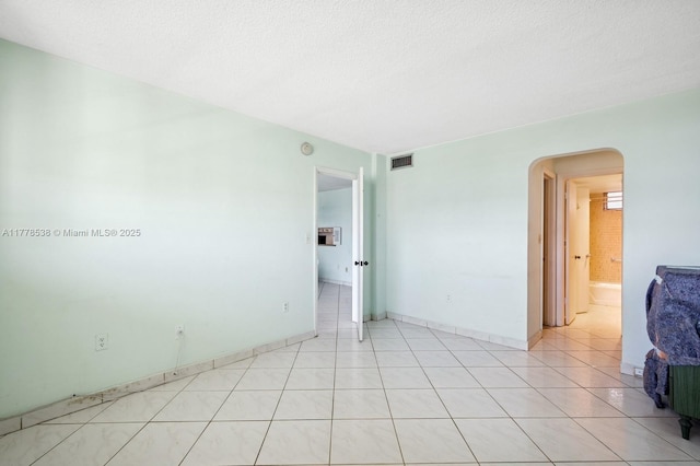 2851 Leonard Dr Unit J610, Aventura, FL 33160 - spare room featuring arched walkways, a textured ceiling, and light tile patterned floors