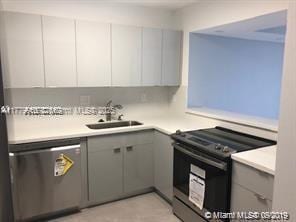 20301 W Country Club Dr Unit 830, Aventura, FL 33180 - kitchen with range with electric cooktop, dishwasher, a sink, light countertops, and gray cabinetry