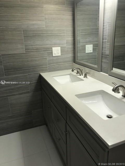20301 W Country Club Dr Unit 830, Aventura, FL 33180 - full bath with double vanity, a sink, tile patterned flooring, and tile walls