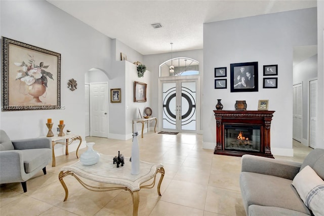 4060 SW 152nd Ave, Miramar, FL 33027 - living room with visible vents, baseboards, light tile patterned floors, arched walkways, and a glass covered fireplace