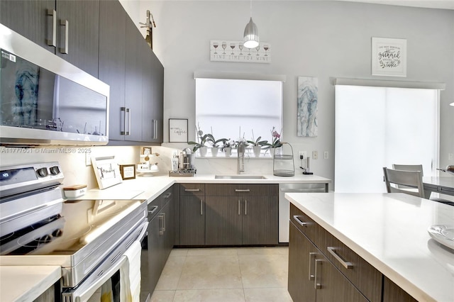 4060 SW 152nd Ave, Miramar, FL 33027 - kitchen featuring dark brown cabinetry, light tile patterned floors, light countertops, appliances with stainless steel finishes, and a sink
