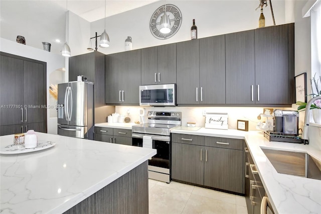 4060 SW 152nd Ave, Miramar, FL 33027 - kitchen featuring stainless steel appliances, light tile patterned floors, a sink, and light stone counters