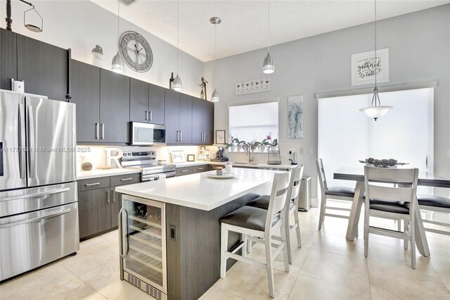 4060 SW 152nd Ave, Miramar, FL 33027 - kitchen featuring light countertops, appliances with stainless steel finishes, a kitchen breakfast bar, a towering ceiling, and beverage cooler