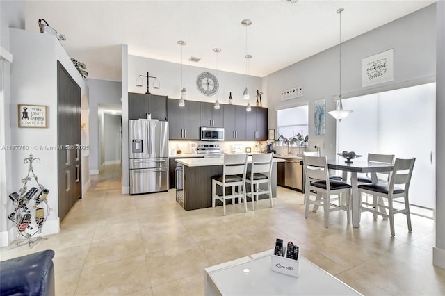 4060 SW 152nd Ave, Miramar, FL 33027 - kitchen with a breakfast bar, a center island, light countertops, decorative light fixtures, and appliances with stainless steel finishes