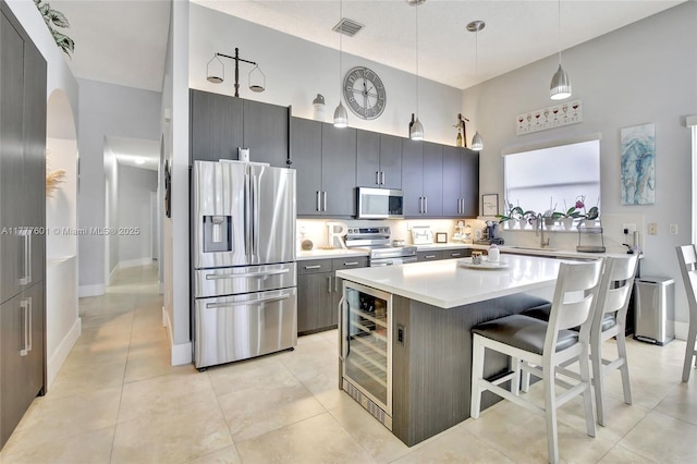 4060 SW 152nd Ave, Miramar, FL 33027 - kitchen with a high ceiling, appliances with stainless steel finishes, light countertops, wine cooler, and a breakfast bar area