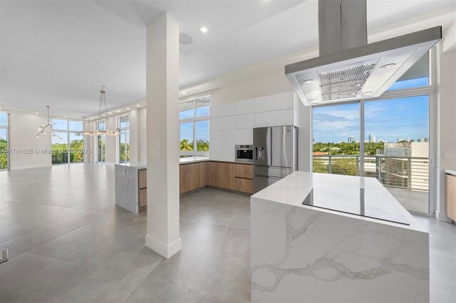 2001 Meridian Ave Unit 514, Miami Beach, FL 33139 - kitchen featuring stainless steel fridge with ice dispenser, range hood, modern cabinets, and a healthy amount of sunlight