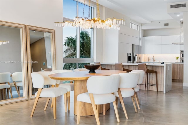 2001 Meridian Ave Unit 514, Miami Beach, FL 33139 - dining area featuring an inviting chandelier, a towering ceiling, and visible vents