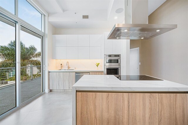 2001 Meridian Ave Unit 514, Miami Beach, FL 33139 - kitchen with stainless steel appliances, range hood, modern cabinets, and light stone counters