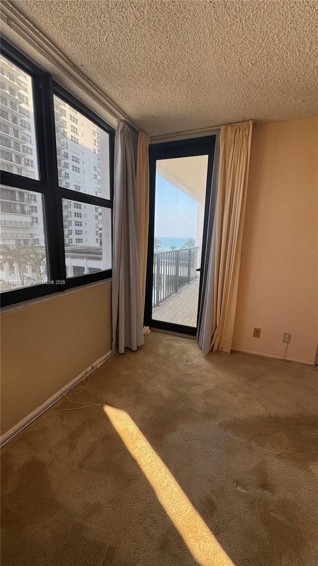 carpeted empty room with a textured ceiling