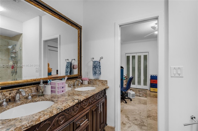 bathroom featuring a stall shower, double vanity, a sink, and ornamental molding