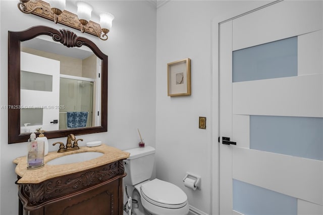 full bath featuring a shower stall, vanity, ornamental molding, and toilet