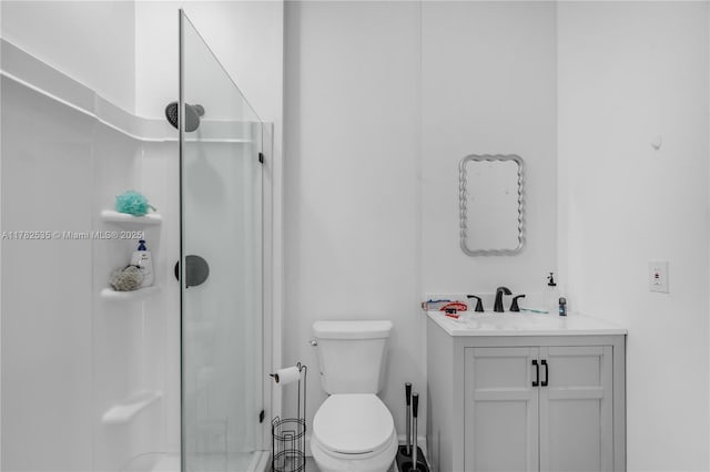 full bathroom with toilet, a stall shower, and vanity