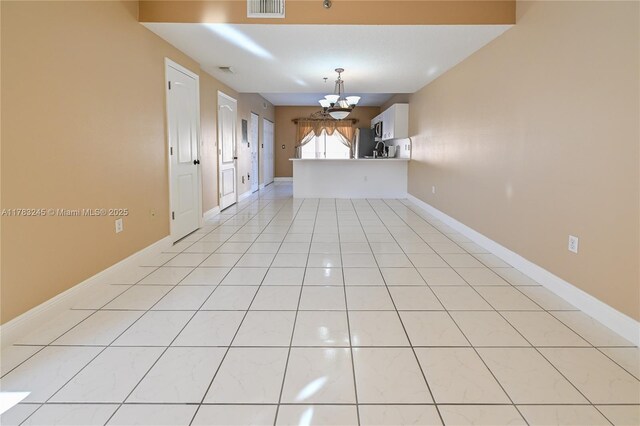 8390 NW 103rd St Unit 205H, Hialeah Gardens, FL 33016 - spare room with visible vents, baseboards, a notable chandelier, and light tile patterned floors