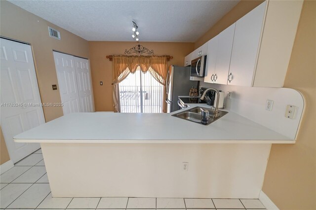 8390 NW 103rd St Unit 205H, Hialeah Gardens, FL 33016 - kitchen featuring a peninsula, light countertops, visible vents, appliances with stainless steel finishes, and a sink
