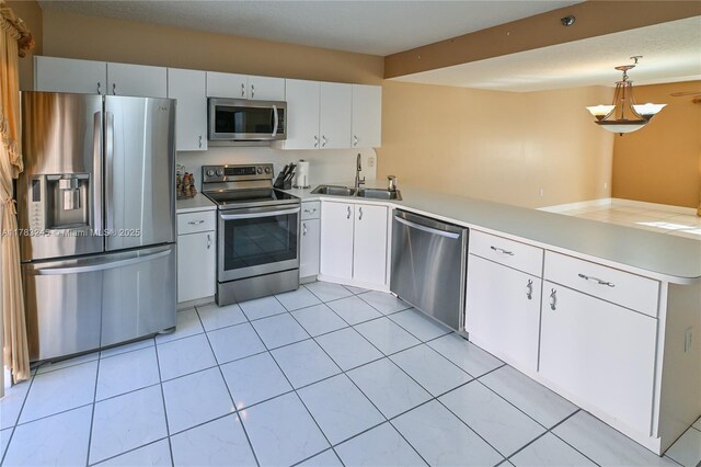 8390 NW 103rd St Unit 205H, Hialeah Gardens, FL 33016 - kitchen with light countertops, a peninsula, appliances with stainless steel finishes, and a sink