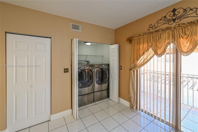 8390 NW 103rd St Unit 205H, Hialeah Gardens, FL 33016 - laundry room with baseboards, light tile patterned floors, visible vents, laundry area, and washer and dryer