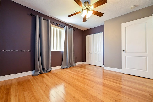 8390 NW 103rd St Unit 205H, Hialeah Gardens, FL 33016 - unfurnished bedroom featuring a closet, light wood finished floors, baseboards, and a ceiling fan