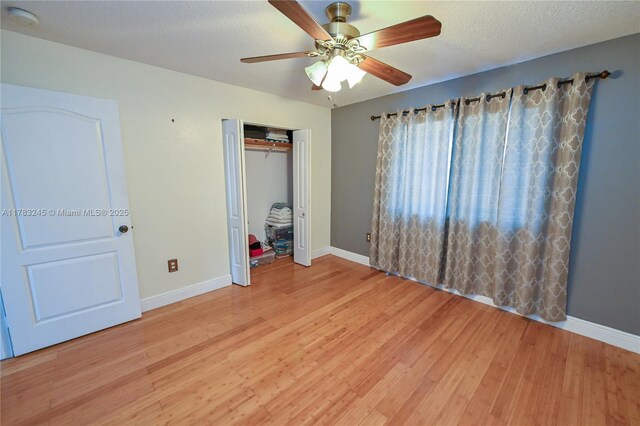 8390 NW 103rd St Unit 205H, Hialeah Gardens, FL 33016 - unfurnished bedroom with a closet, baseboards, light wood-type flooring, and ceiling fan