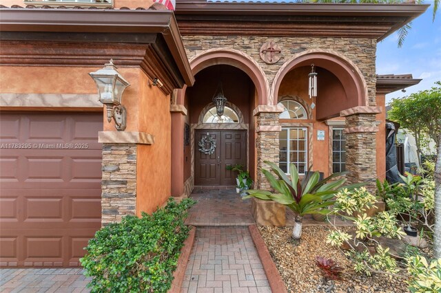 property entrance with stone siding and a garage
