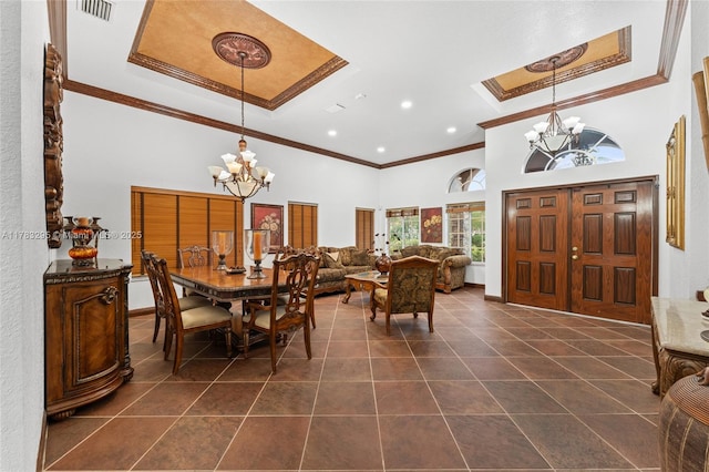 dining room featuring a chandelier, a towering ceiling, ornamental molding, and a tray ceiling