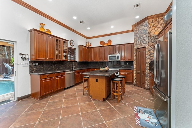 kitchen featuring crown molding, tasteful backsplash, visible vents, dark countertops, and stainless steel appliances