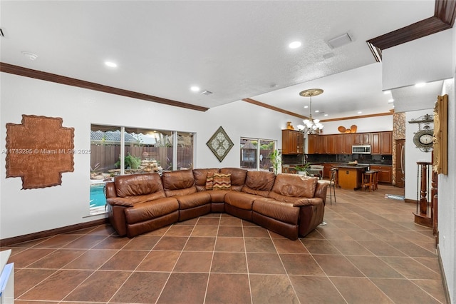 living area with an inviting chandelier, crown molding, and dark tile patterned flooring