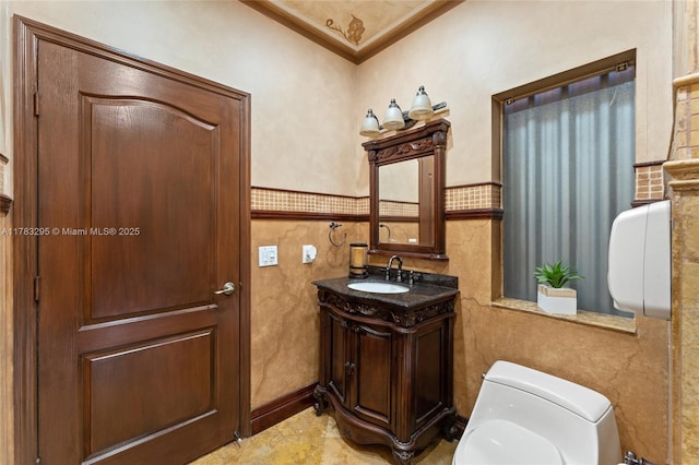half bathroom with crown molding, toilet, and vanity