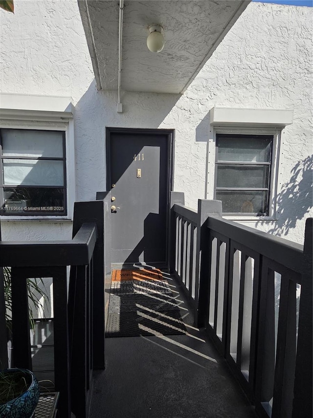 doorway to property featuring stucco siding
