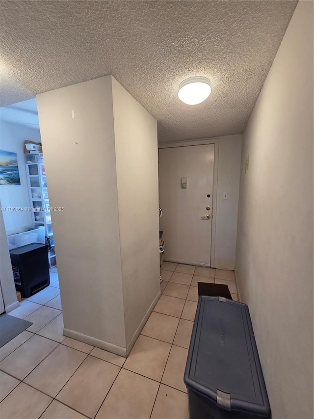 hallway featuring light tile patterned floors and a textured ceiling