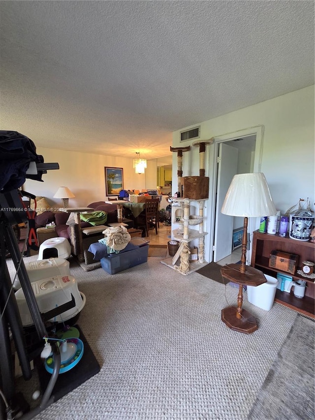 living area featuring visible vents, a textured ceiling, and carpet floors