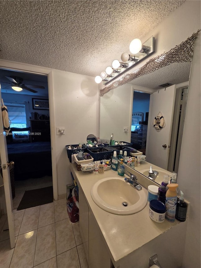 bathroom with vanity, connected bathroom, tile patterned flooring, and a textured ceiling