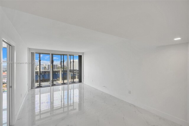 3625 N Country Club Dr Unit 2310, Aventura, FL 33180 - spare room featuring baseboards, a water view, and marble tiled floors