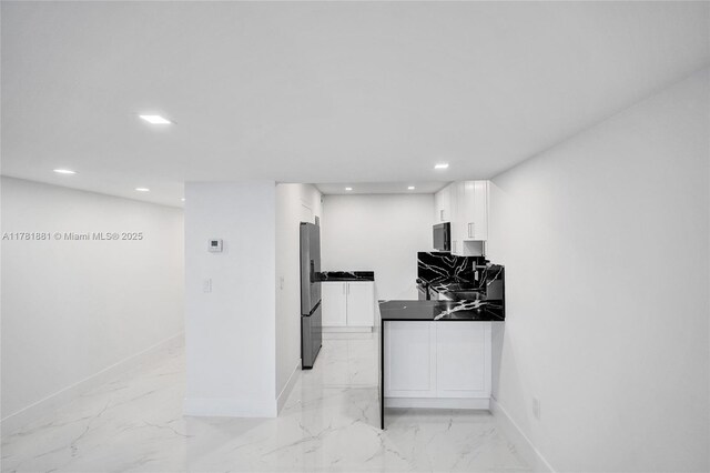 3625 N Country Club Dr Unit 2310, Aventura, FL 33180 - kitchen with freestanding refrigerator, baseboards, dark countertops, white cabinets, and light marble finish flooring