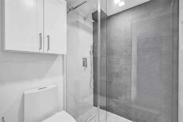 bathroom with a marble finish shower and toilet